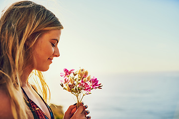 Image showing Dont lose your connection to nature. a happy young woman holding a bunch of flowers while standing outside.