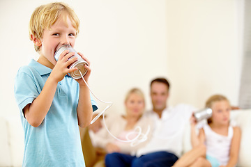 Image showing Ill give her something to listen to. A little boy shouting loudly into a tin can connected to another that his sister is holding.