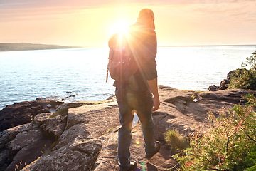 Image showing Hiking pushes you to find new trails. a man wearing his backpack while out for a hike on a coastal trail.