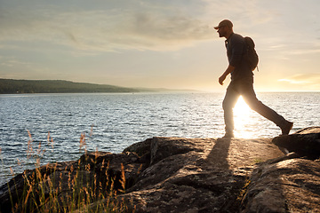 Image showing Every moment is special when youre out hiking. a man wearing his backpack while out for a hike on a coastal trail.