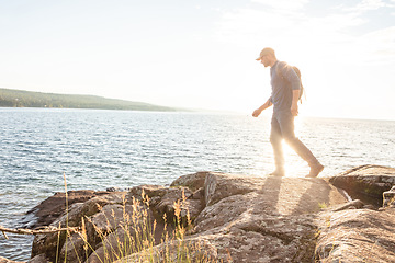 Image showing I want to get really close. a man wearing his backpack while out for a hike on a coastal trail.