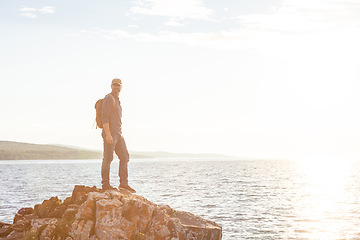 Image showing Hiking is undoubtedly a fun and rewarding pastime. a man wearing his backpack while out for a hike on a coastal trail.