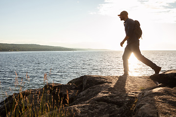 Image showing Experience the true freedom of movement. a man wearing his backpack while out for a hike on a coastal trail.
