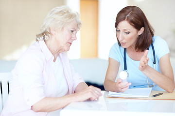 Image showing Explaining a solution to her problems - Senior Healthcare. Mature doctor explains an elderly womans prescription medication to her.