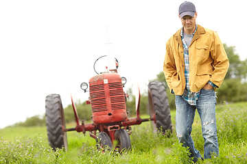 Image showing Nature walk. Full length image of a farmer standing next to his tractor in a field.