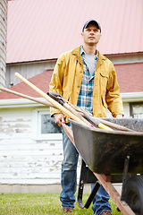 Image showing I work hard. A serious man standing outside with his wheelbarrow.