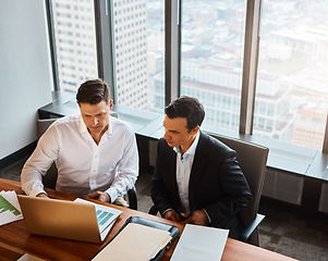 Image showing Without a goal, you can’t score. two businessmen having a discussion while sitting by a laptop.