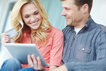 Image showing Doing some shopping together. a happy mature couple shopping online using a digital tablet while relaxing together at home.