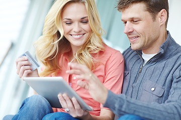 Image showing Together in everything. a happy mature couple shopping online using a digital tablet while relaxing together at home.