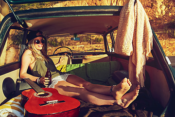 Image showing Go your own way. a young woman relaxing in the back of her car on a roadtrip.