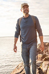 Image showing We learn something new on every walk through nature. a man wearing his backpack while out for a hike on a coastal trail.