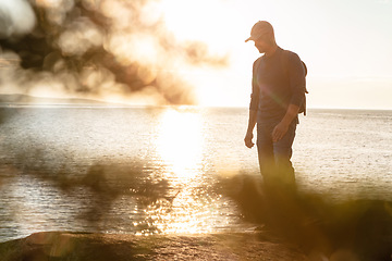 Image showing Hiking goes beyond exercise. a man wearing his backpack while out for a hike on a coastal trail.