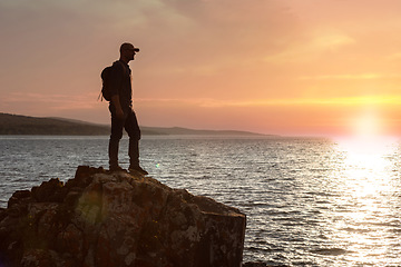 Image showing I have a need to get close to nature. a man wearing his backpack while out for a hike on a coastal trail.
