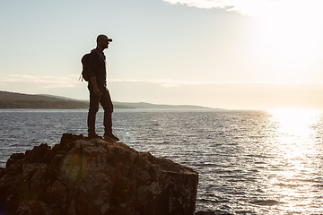 Image showing Every hike seems even better than the previous one. a man wearing his backpack while out for a hike on a coastal trail.