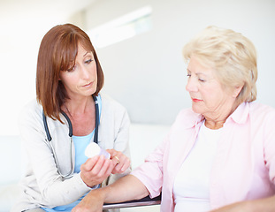 Image showing Professional nurse prescribing to her elderly patient. Mature nurse explains the dosage and side effects of the medication to an elderly female patient.