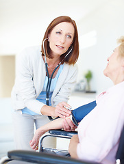 Image showing Checking her pulse and blood pressure - Senior Care. Mature nurse checks an elderly female patients blood pressure.