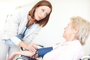 Image showing I want to be certain your body isnt under any undue pressure. Mature nurse checks an elderly female patients blood pressure.