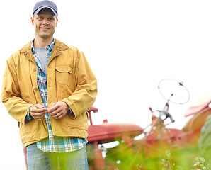 Image showing The happiest life is a simple one. Portrait of a farmer standing in a field with his tractor parked behind him - Copyspace.