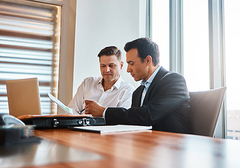 Image showing Were taking our business global. two mature businessmen discussing paperwork in a corporate office.