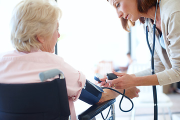 Image showing Ensuring her patients blood pressure is normal. Rear-view of a wheelchair-bound elderly patient getting her blood pressure checked by a nurse.