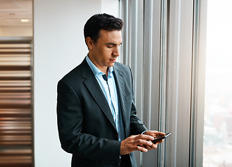 Image showing I give advice when you need it. a well-dressed businessman using his cellphone at the office.