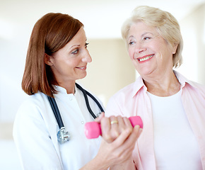 Image showing Acknowledging the teamwork it took to recover - Senior Health. Determined elderly female is assisted by her nurse as she lifts a dumbbell.