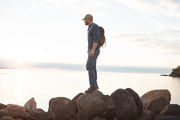 Image showing Im here for the workout and the view. a man looking at the ocean while out hiking.