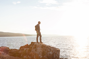 Image showing Id do it over and over to get to this part. a man wearing his backpack while out for a hike on a coastal trail.