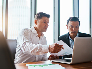 Image showing Managing our business. two businessmen having a discussion while sitting by a laptop.