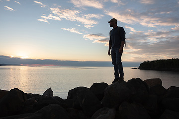 Image showing A good hike completes my day. a man wearing his backpack while out for a hike on a coastal trail.