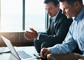 Image showing It time to expand our services. two businessmen having a discussion while sitting by a laptop.