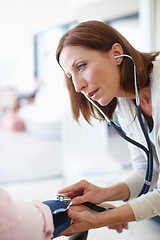 Image showing Listening intently to the heartbeat. Closeup of a mature nurse checking the blood pressure and listening to the pulse of her patient.