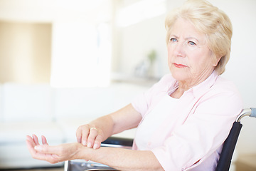 Image showing Elderly woman in a wheelchair checking her pulse at the wrist