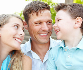 Image showing Spending quality time with their father. Handsome father embracing his teen daughter and young son while outdoors.