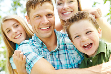 Image showing They enjoy every moment together. A happy young family relaxing together on a sunny day.