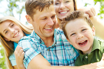 Image showing Sharing laughter and smile together. A happy young family relaxing together on a sunny day.