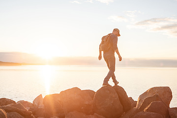 Image showing Theres always a reason to go exploring. a man wearing his backpack while out for a hike on a coastal trail.