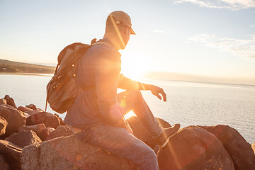 Image showing Im always out exploring. a man looking at the ocean while out hiking.