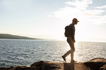 Image showing Hiking will take you to wonderful places. a man wearing his backpack while out for a hike on a coastal trail.