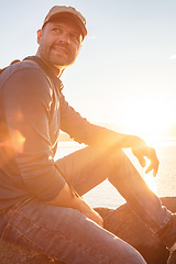 Image showing Im surely enjoying myself out here. a man wearing his backpack while out for a hike on a coastal trail.