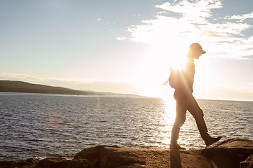 Image showing Hiking is not easy, but its worth it. a man wearing his backpack while out for a hike on a coastal trail.