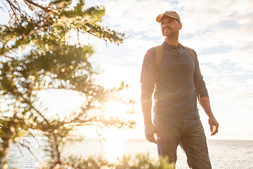 Image showing Learn to live in the moment. a man wearing his backpack while out for a hike on a coastal trail.