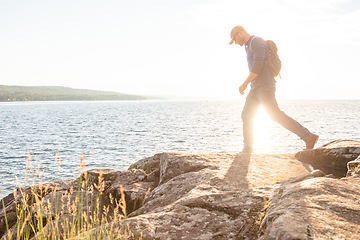 Image showing I love to challenge myself. a man wearing his backpack while out for a hike on a coastal trail.