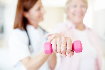 Image showing Professional care and rehabilitation - Senior Health. Closeup of a pink dumbbell being lifted by an elderly female assisted by her nurse in background.