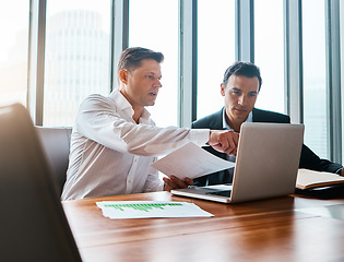 Image showing Were better when we work together. two businessmen having a discussion while sitting by a laptop.