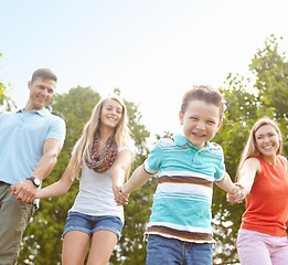 Image showing Holding hands in the park. Low angle shot of a family walking hand in hand outside.