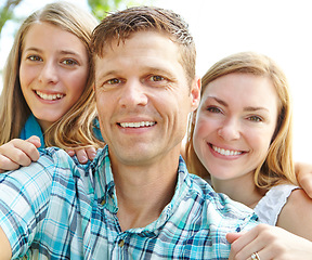 Image showing Proud of his beautiful family. A happy young family relaxing together on a sunny day.