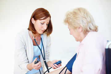 Image showing Getting the readings on her patients blood pressure. Mature nurse checks an elderly female patients blood pressure.