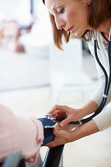 Image showing Clinical and professional examination. Closeup of a mature nurse checking the blood pressure of her patient.