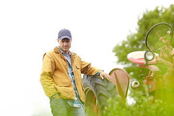 Image showing Thinking of the best way to harvest his crops. a thoughtful farmer leaning against his tractor while looking down.